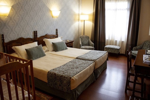 une chambre d' hôtel avec un lit jumeau et un berceau