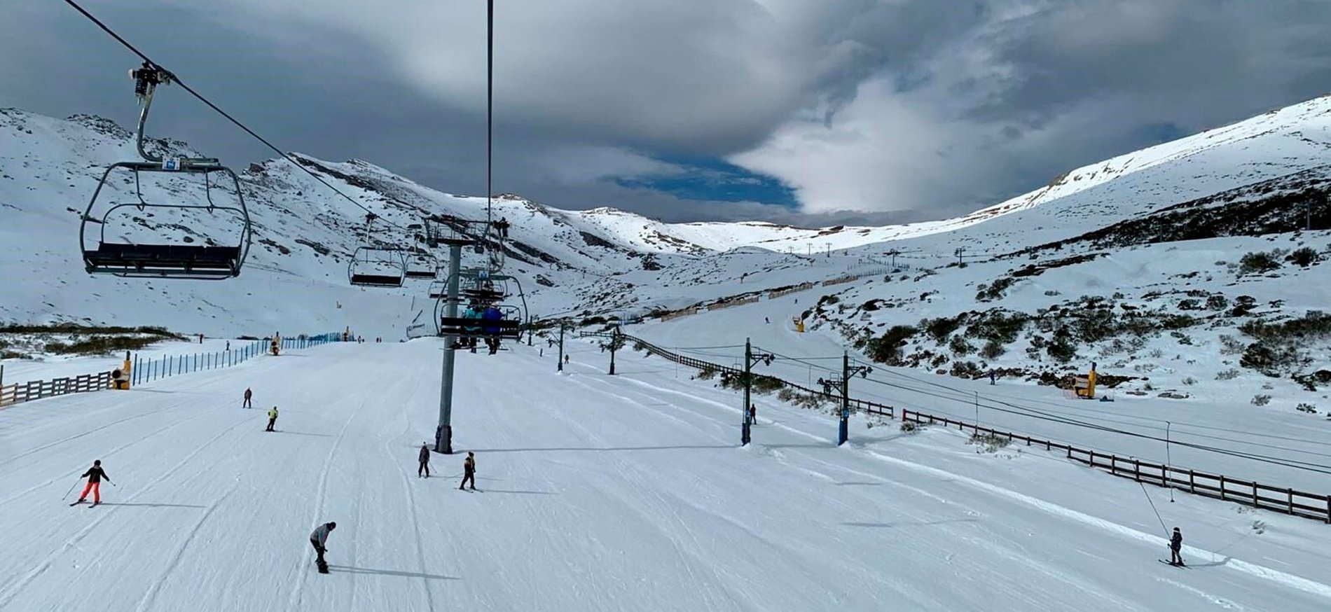 un grupo de esquiadores y un teleférico en una ladera cubierta de nieve