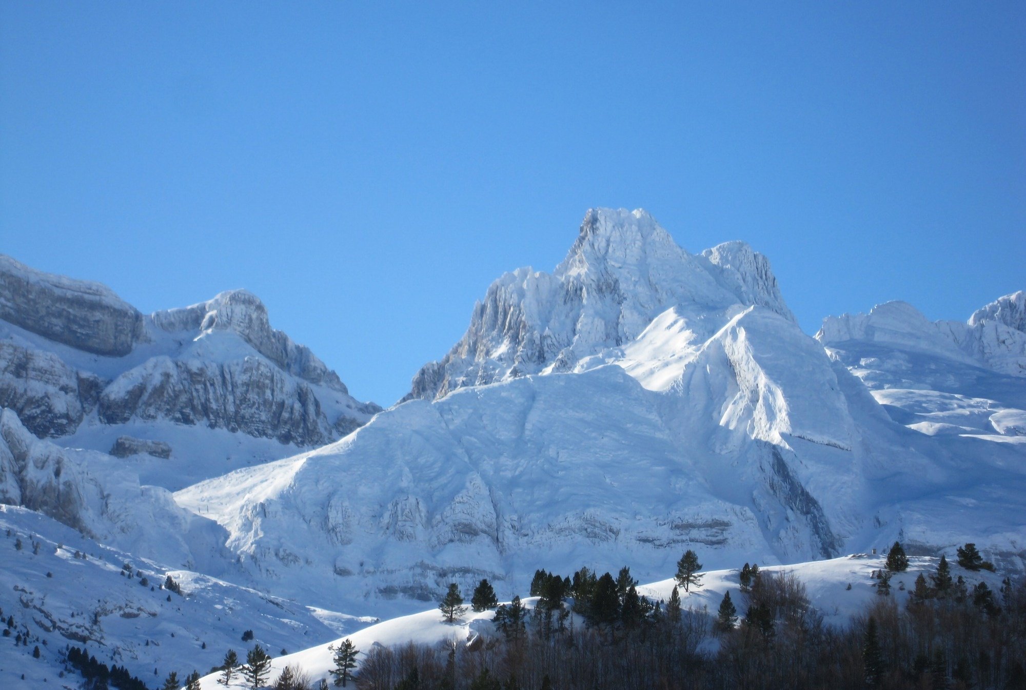 a snowy mountain with a blue sky in the background