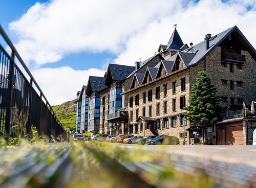 un grand bâtiment en pierre avec des voitures garées devant