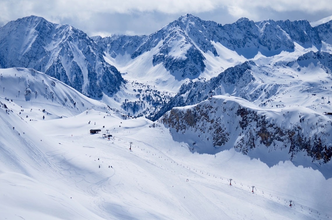 snow covered mountains with a ski lift in the foreground