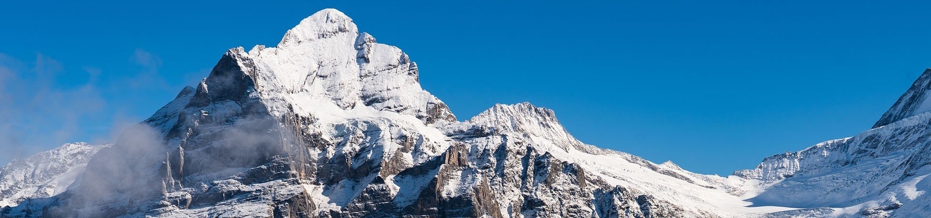 a snowy mountain with a blue sky in the background