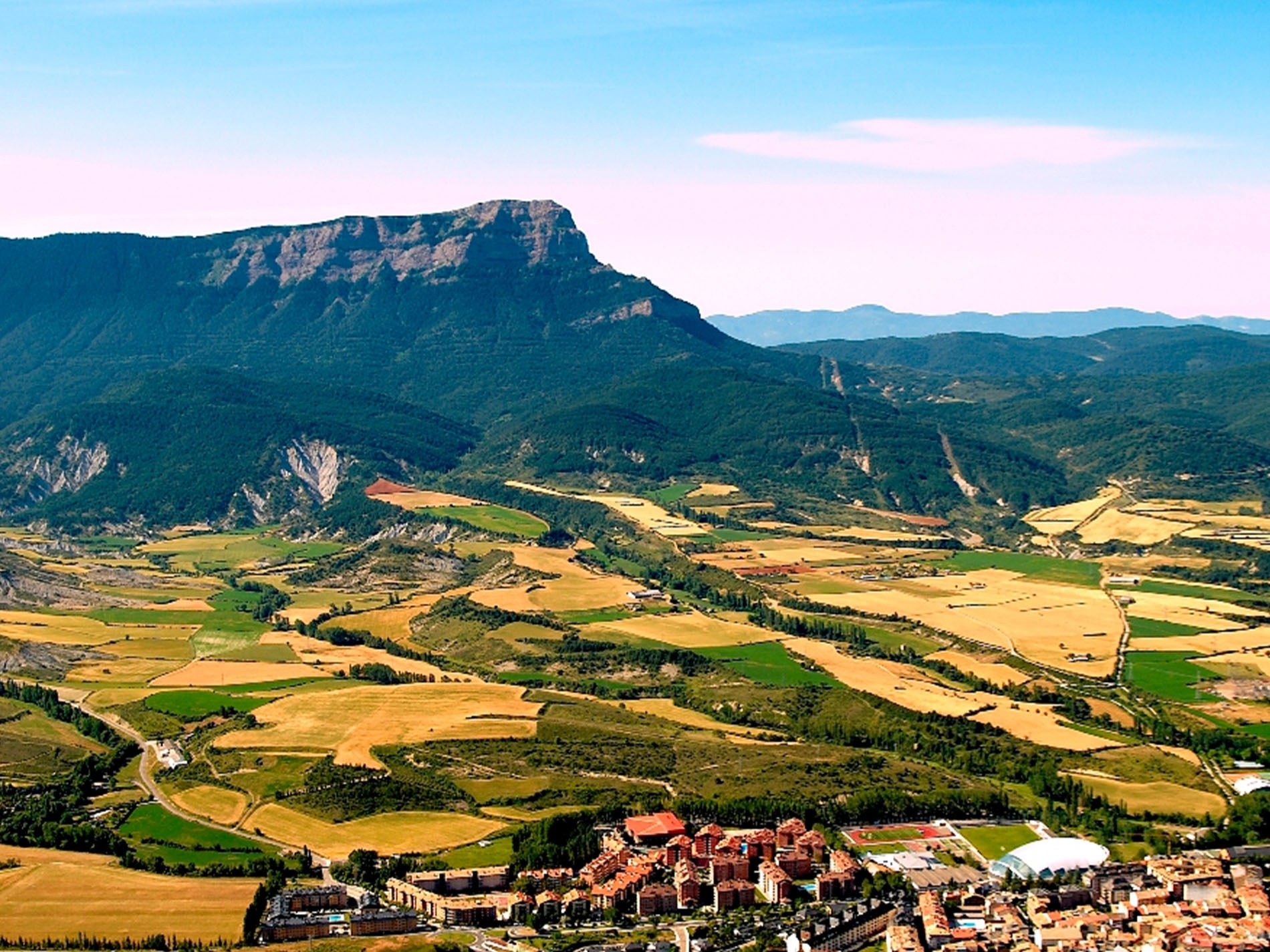 un lago en medio de un valle rodeado de montañas y árboles .