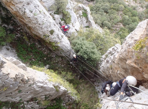a group of people are climbing up a rocky cliff