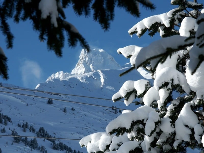 montañas cubiertas de nieve con un cielo azul en el fondo