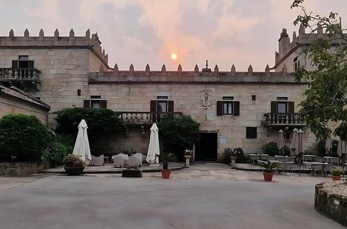 un bâtiment en pierre avec des parasols et des tables à l' extérieur
