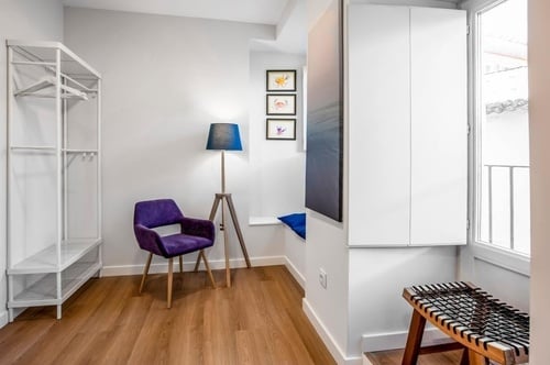 a room with a purple chair and a lamp