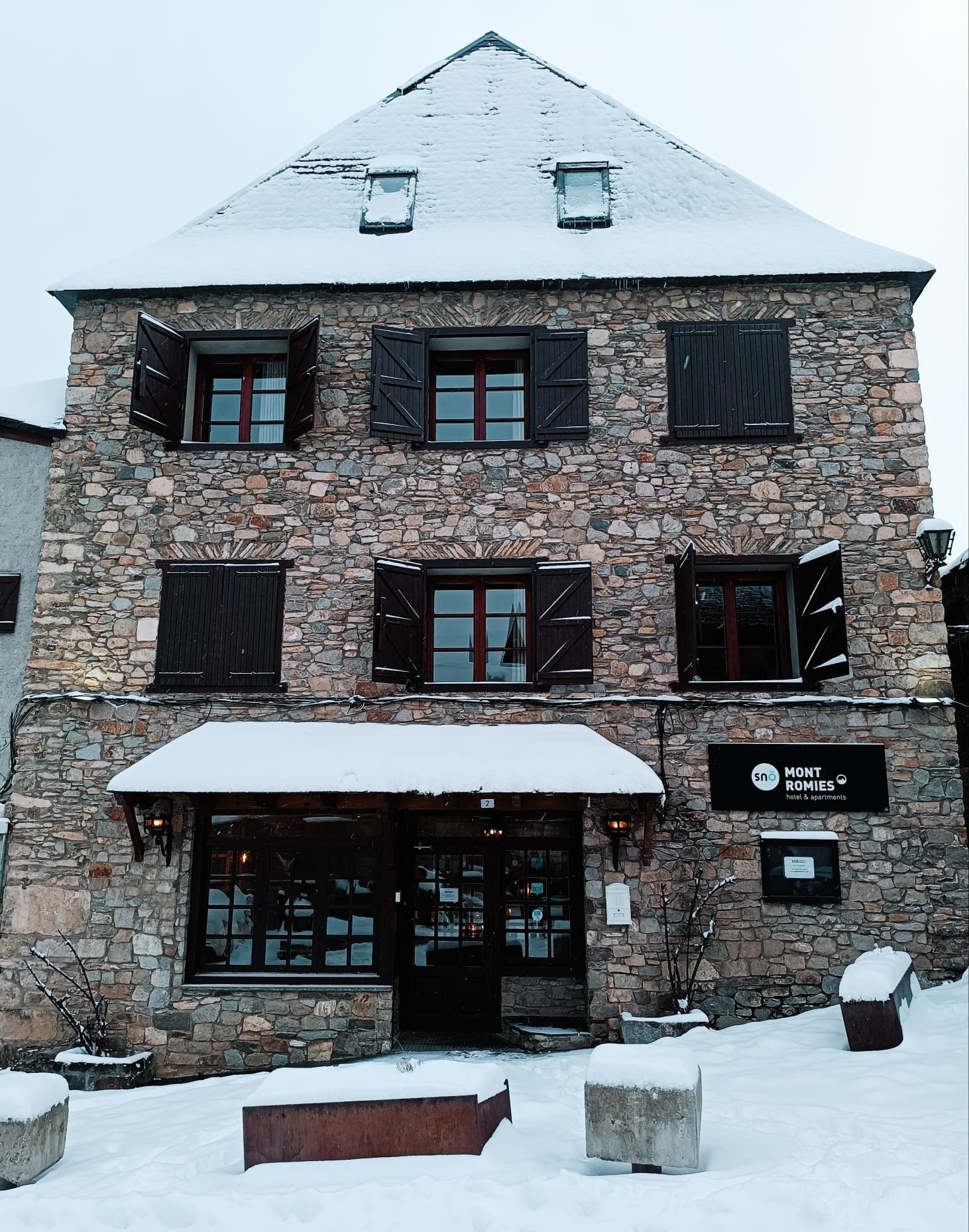 un bâtiment en pierre avec des fenêtres couvertes de neige