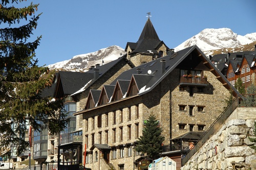 un grand bâtiment en pierre avec une montagne en arrière-plan