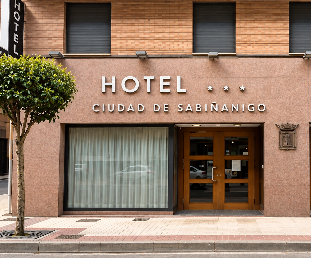 Hotel Snö Ciudad de Sabiñánigo, un hotel confortable en Huesca con fachada moderna y árboles.