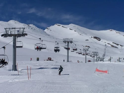 a ski lift is going up a snowy mountain