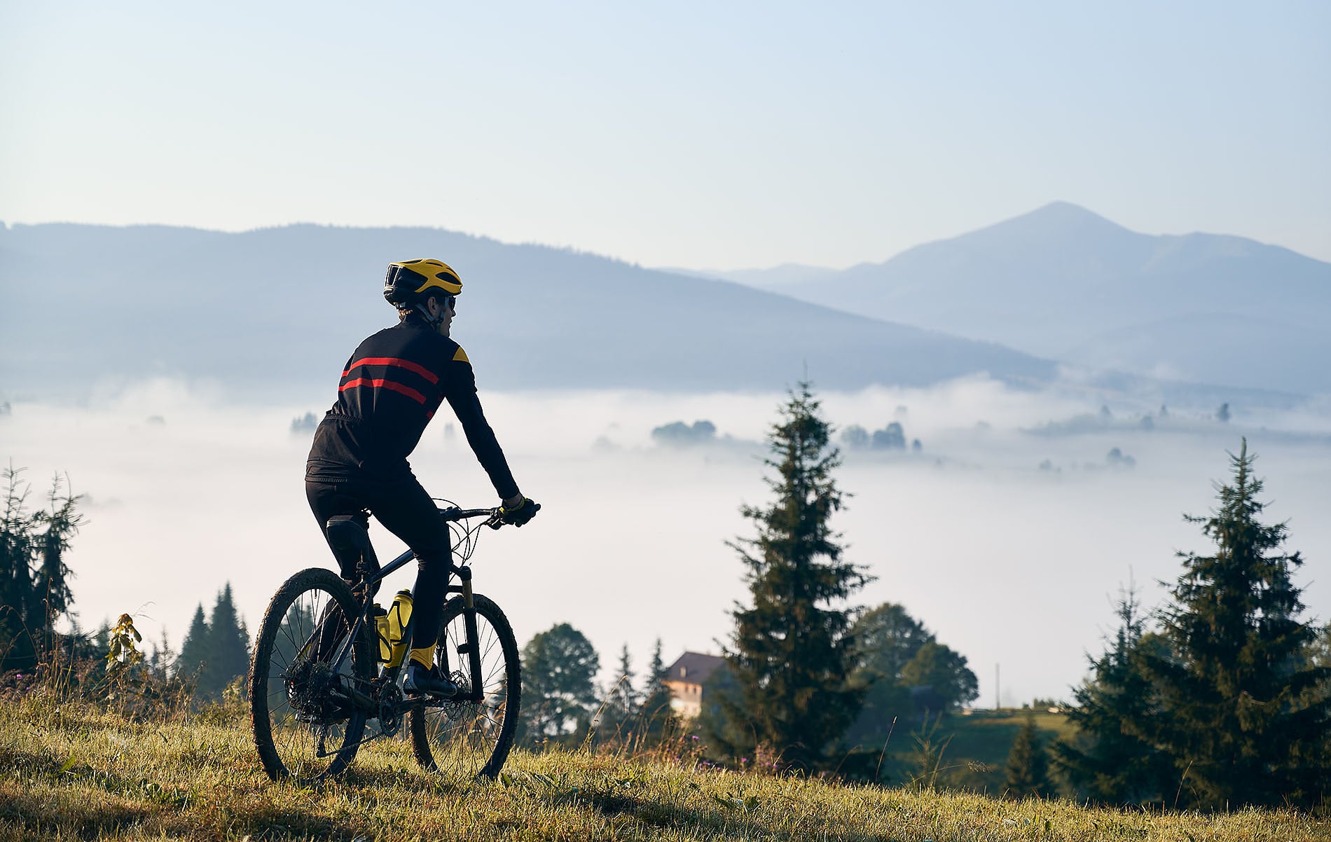 Ciclista enSNO: Corporativa montañas, disfrutando del amanecer y la niebla.