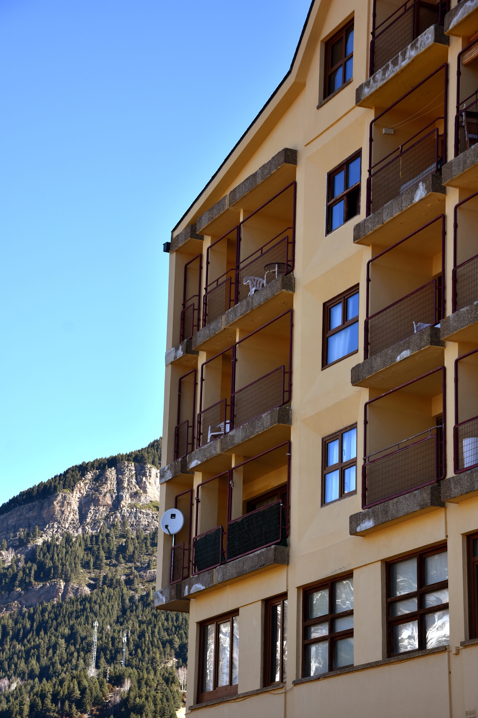 un edificio amarillo está rodeado de árboles y hierba