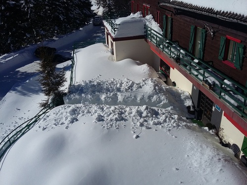 une grande pile de neige est assise devant un bâtiment