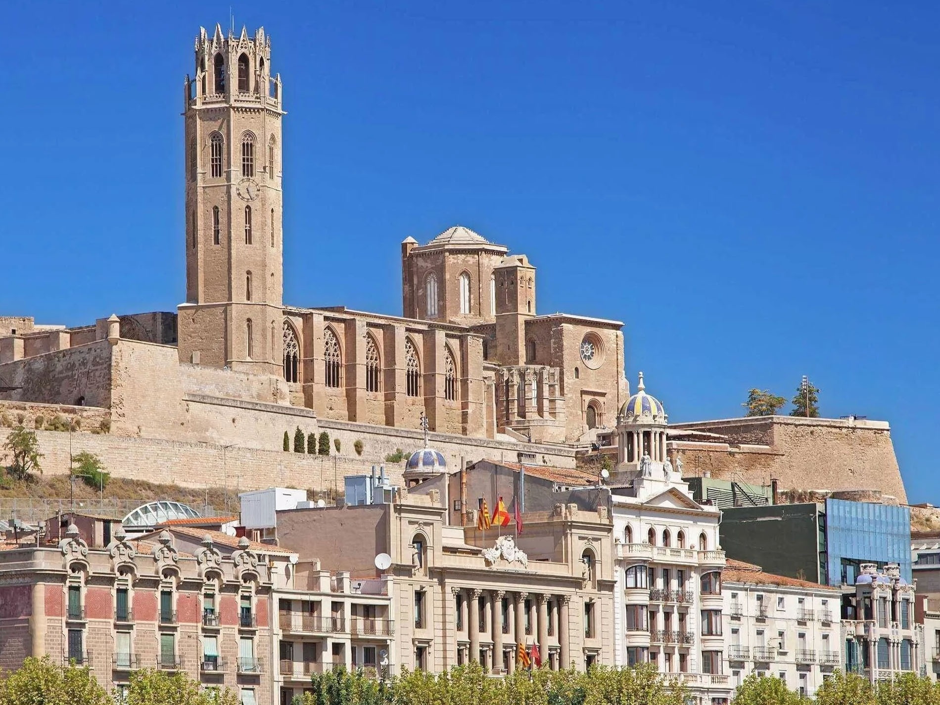 un coche está estacionado frente a un edificio de apartamentos