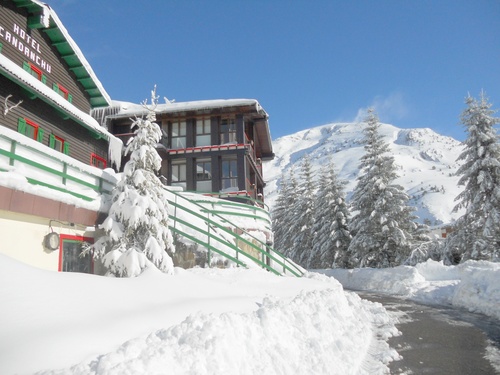 un edificio cubierto de nieve con la palabra hotel candauchi en la parte superior