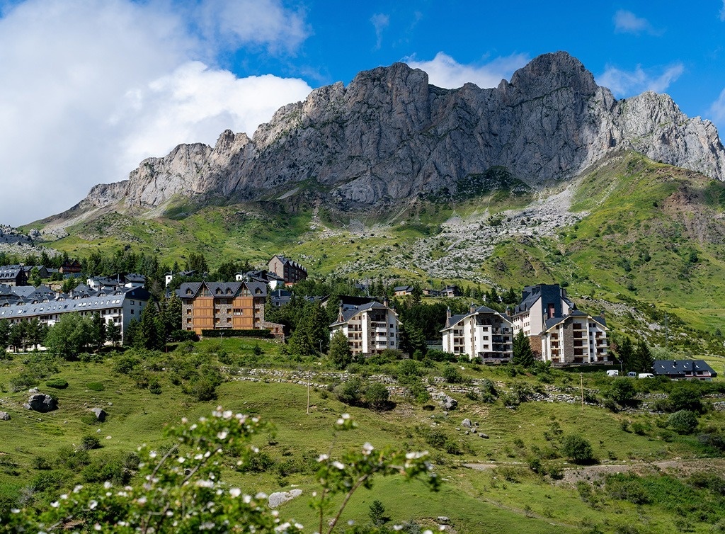 un village de montagne avec des maisons et des montagnes en arrière-plan