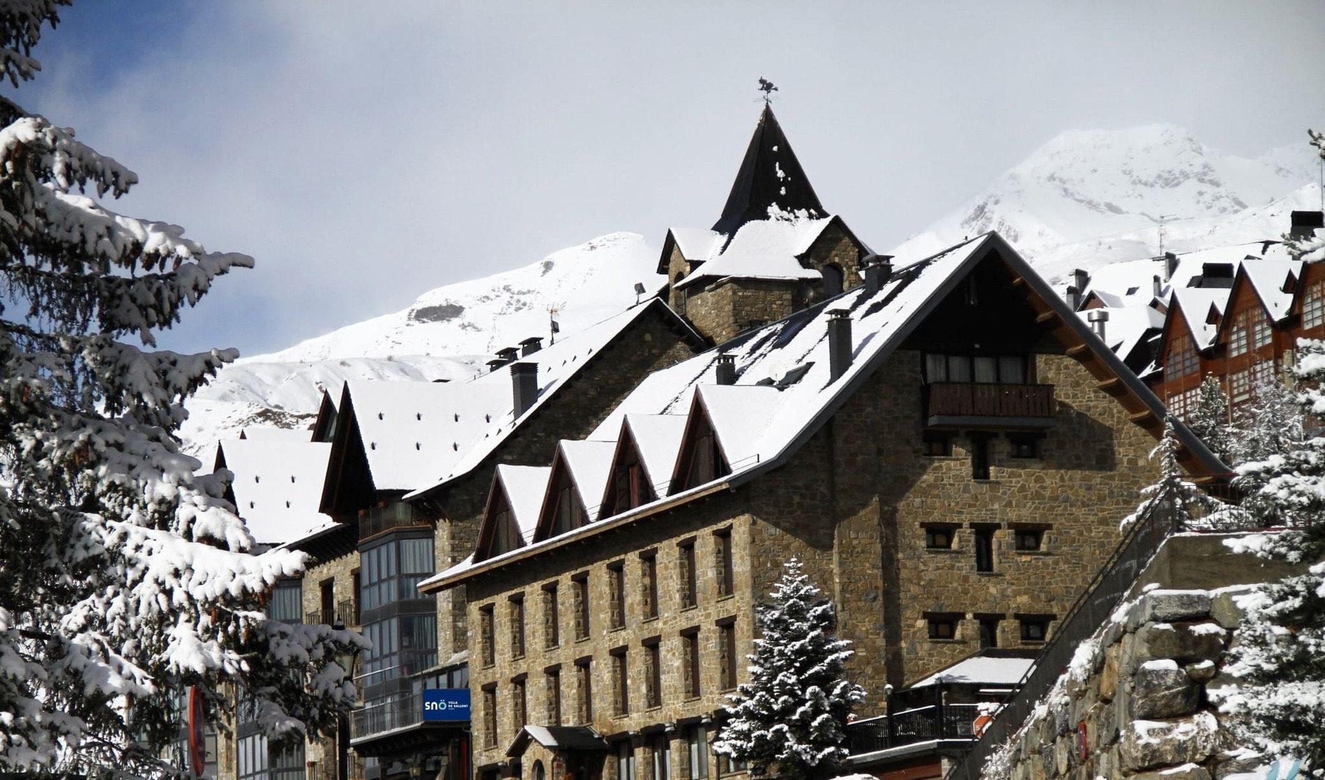 a snow covered building with a weather vane on top of it