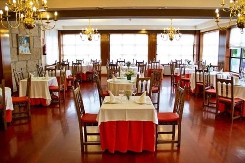 a dining room with tables and chairs and a picture on the wall