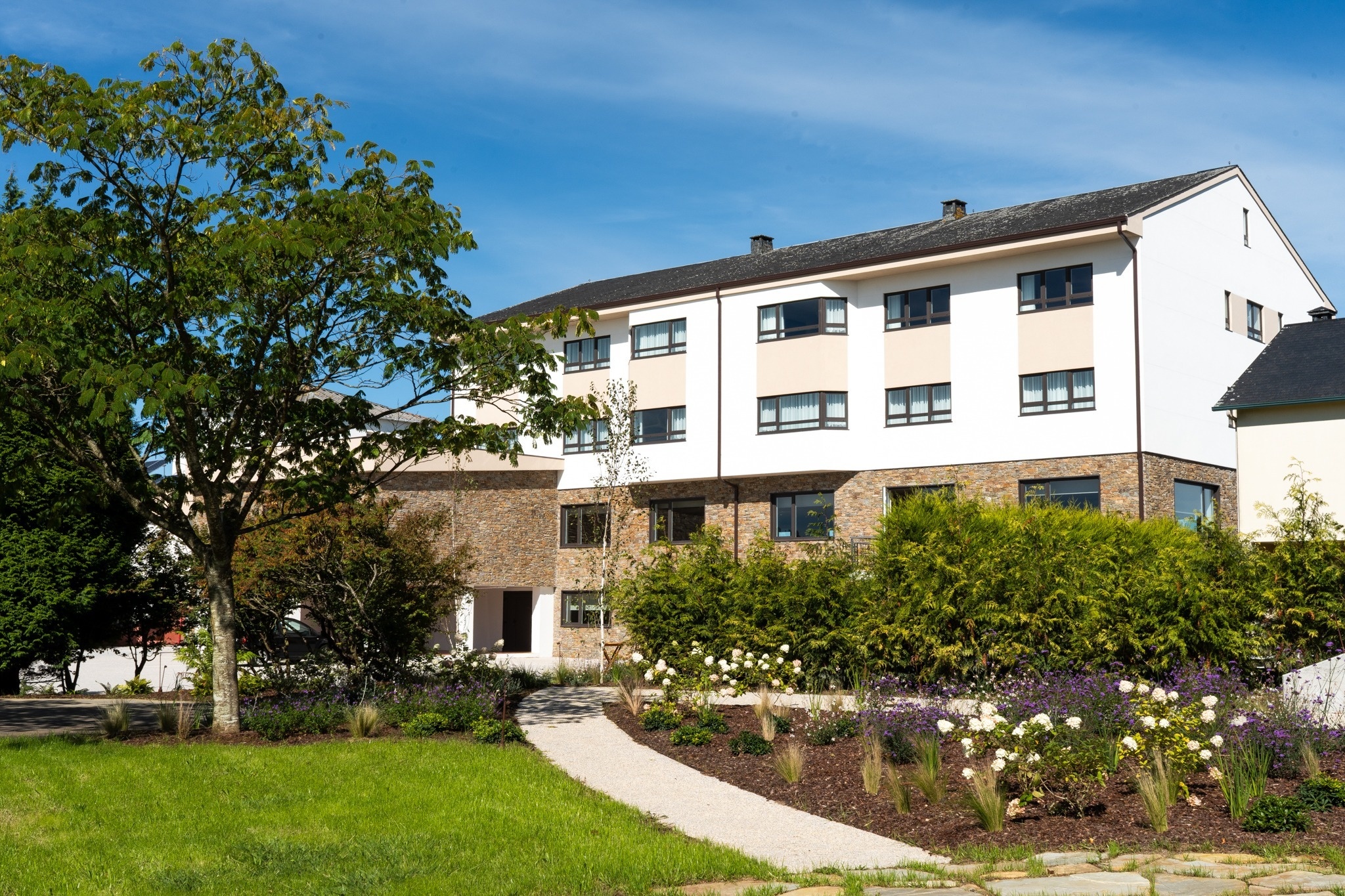 un coche está estacionado frente a un edificio de apartamentos