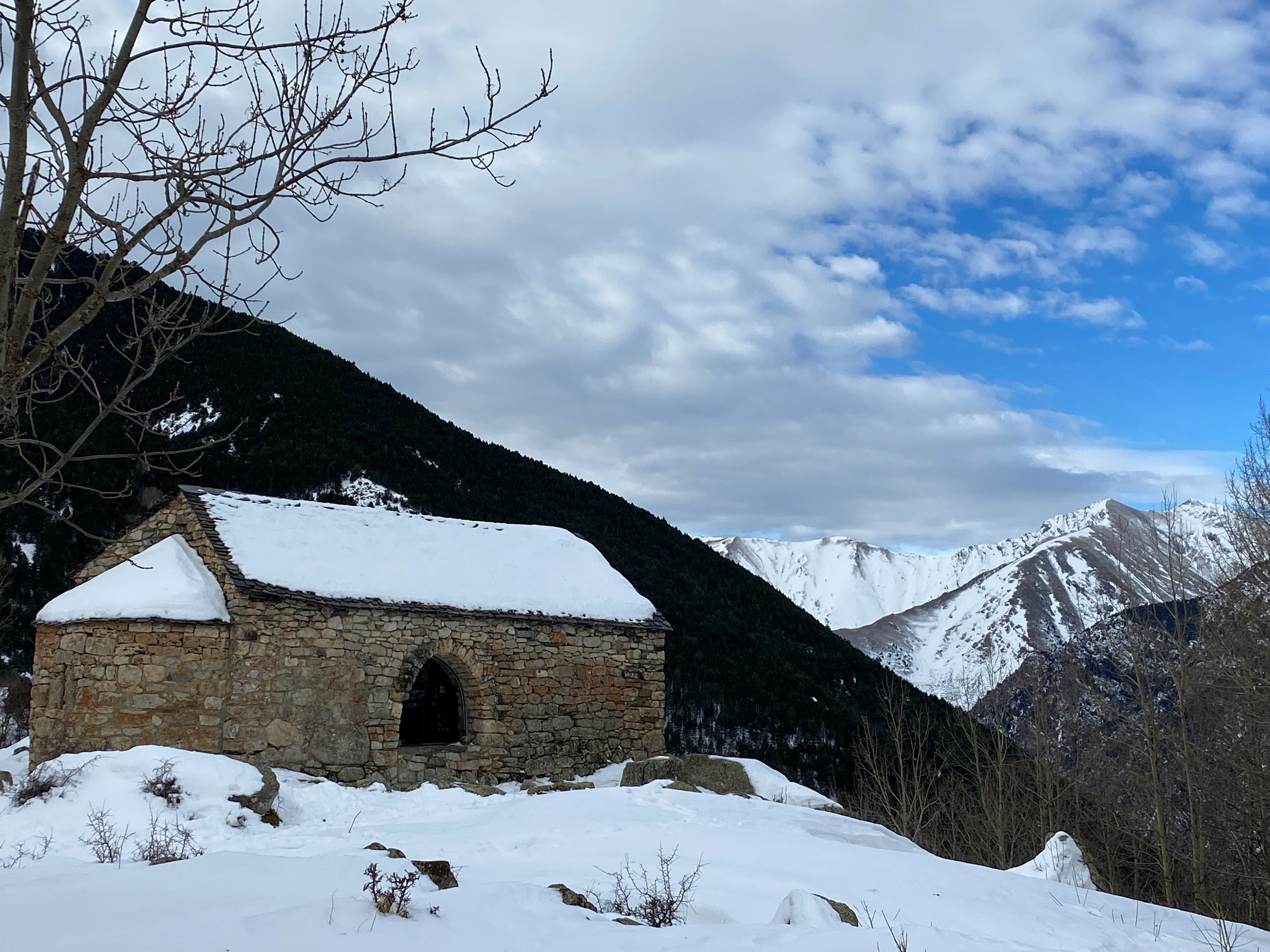 una iglesia de piedra cubierta de nieve en las montañas