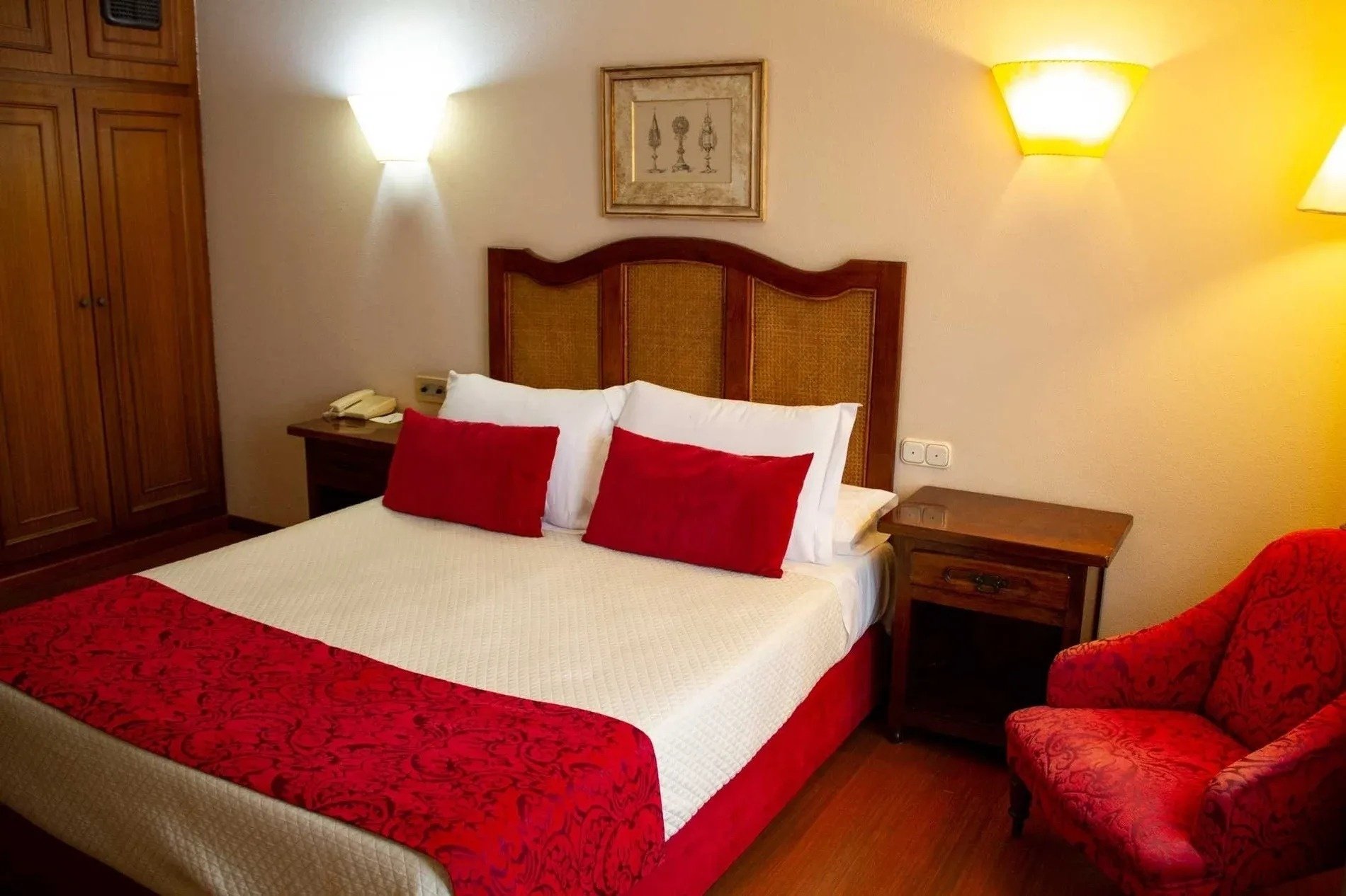 une chambre d' hôtel avec un lit et une chaise rouges