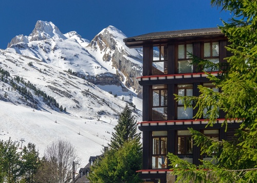 a building with a snowy mountain in the background
