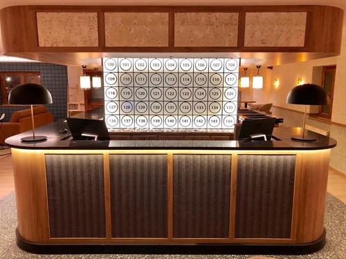 a reception desk with a wall of numbers on it