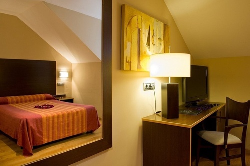 una habitación con una cama y un escritorio con una televisión