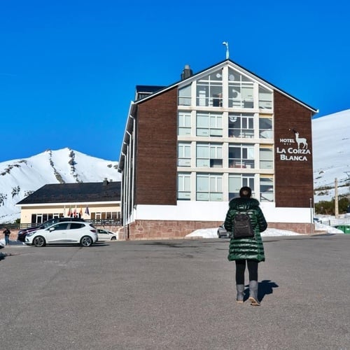 una mujer camina hacia el hotel la corza blanca