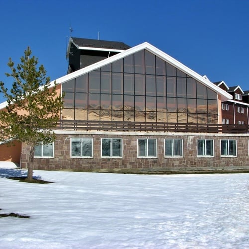 un gran edificio con muchas ventanas está cubierto de nieve