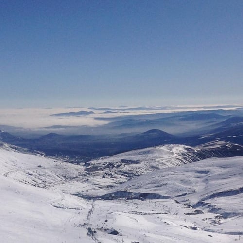 un valle cubierto de nieve con montañas en el fondo