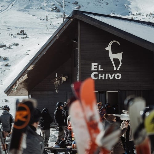 un grupo de esquiadores se reúnen frente a la tienda el chivo