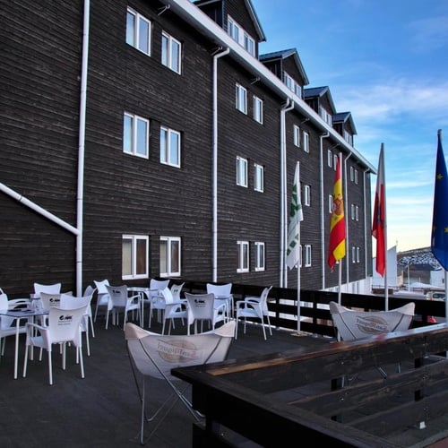 un bâtiment en bois avec des tables et des chaises à l' extérieur