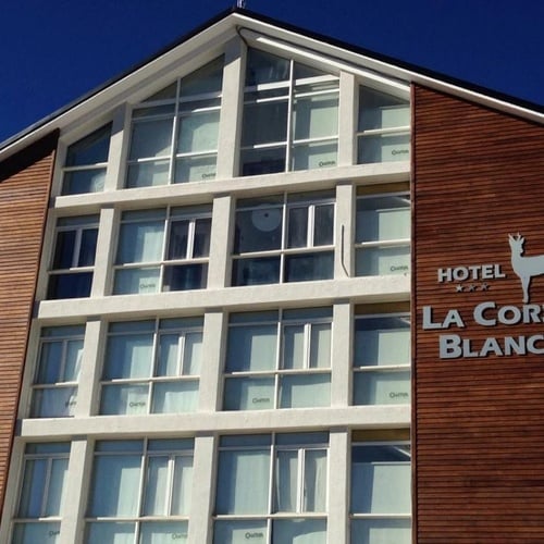 un gran edificio de madera con la palabra hotel la corza blanca encima