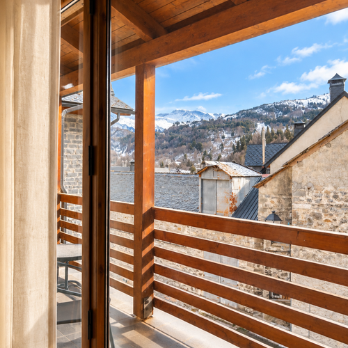 Salon confortable des Apartamentos Escarrilla avec canapé, table et vue sur l'extérieur.