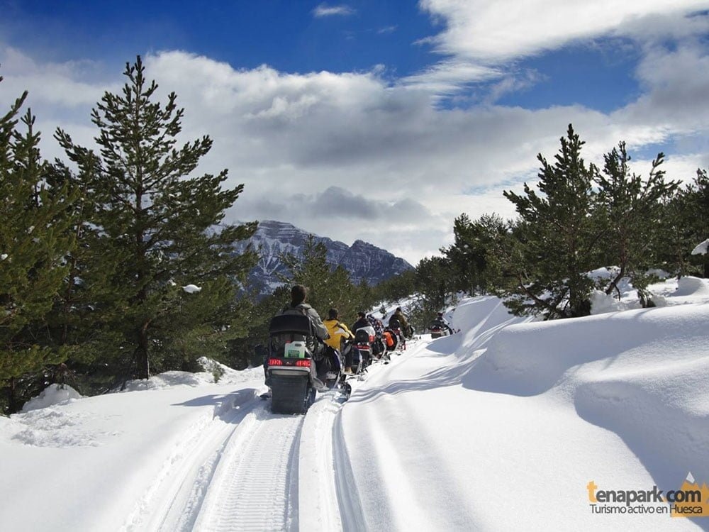 un parapente rojo y blanco está volando sobre una montaña