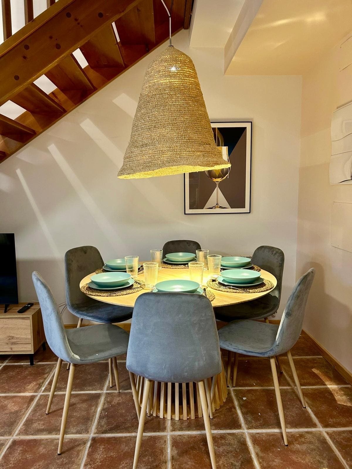 une salle à manger avec une table et des chaises et un escalier en bois