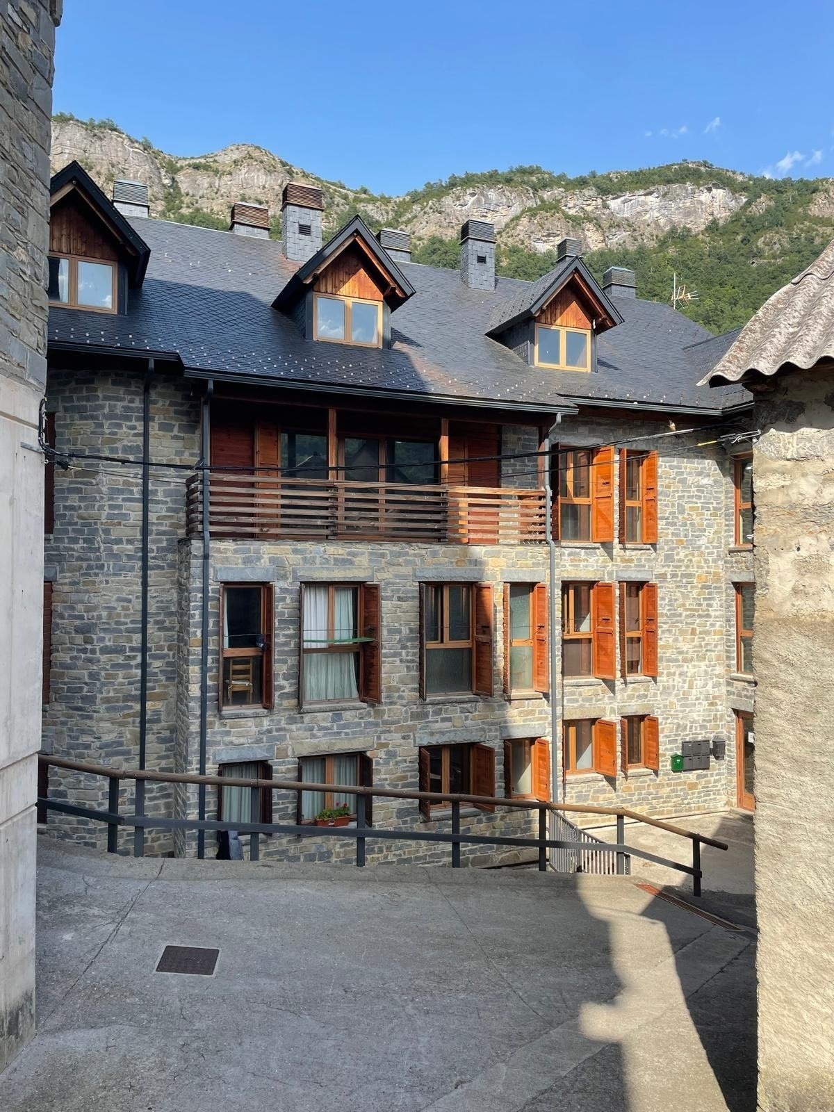 un edificio de piedra con un techo de pizarra y balcones de madera