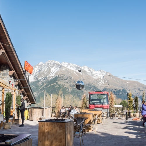 a red truck is parked in front of a restaurant with mountains in the background