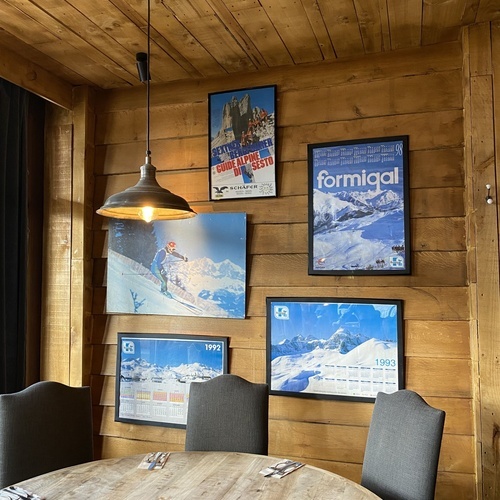 une salle à manger avec une table en bois et des affiches accrochées au mur