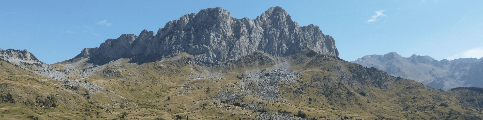 une grande montagne avec un ciel bleu en arrière-plan