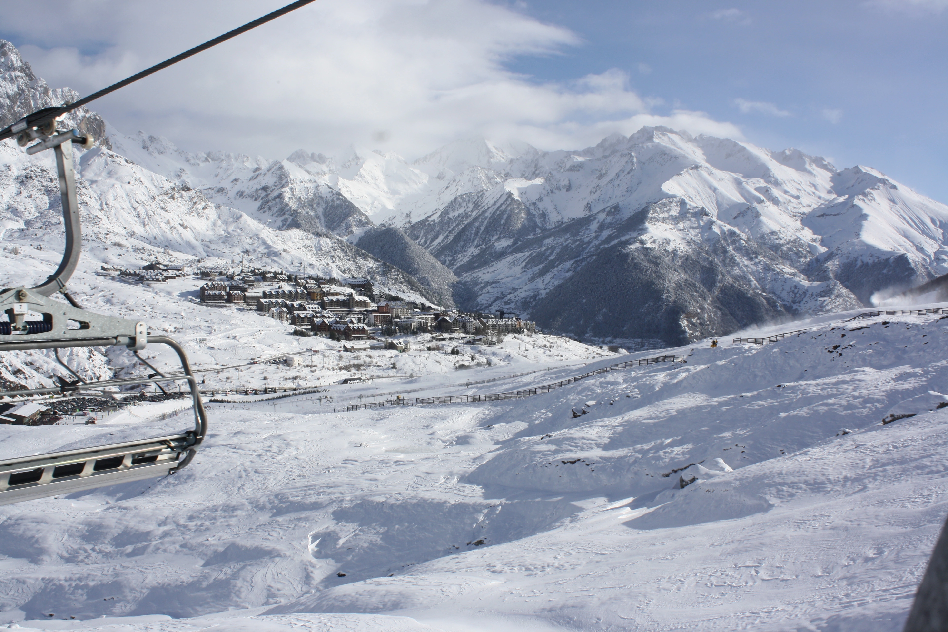 Esquí en SNO: Formigal con vistas a las montañas nevadas y el pueblo.