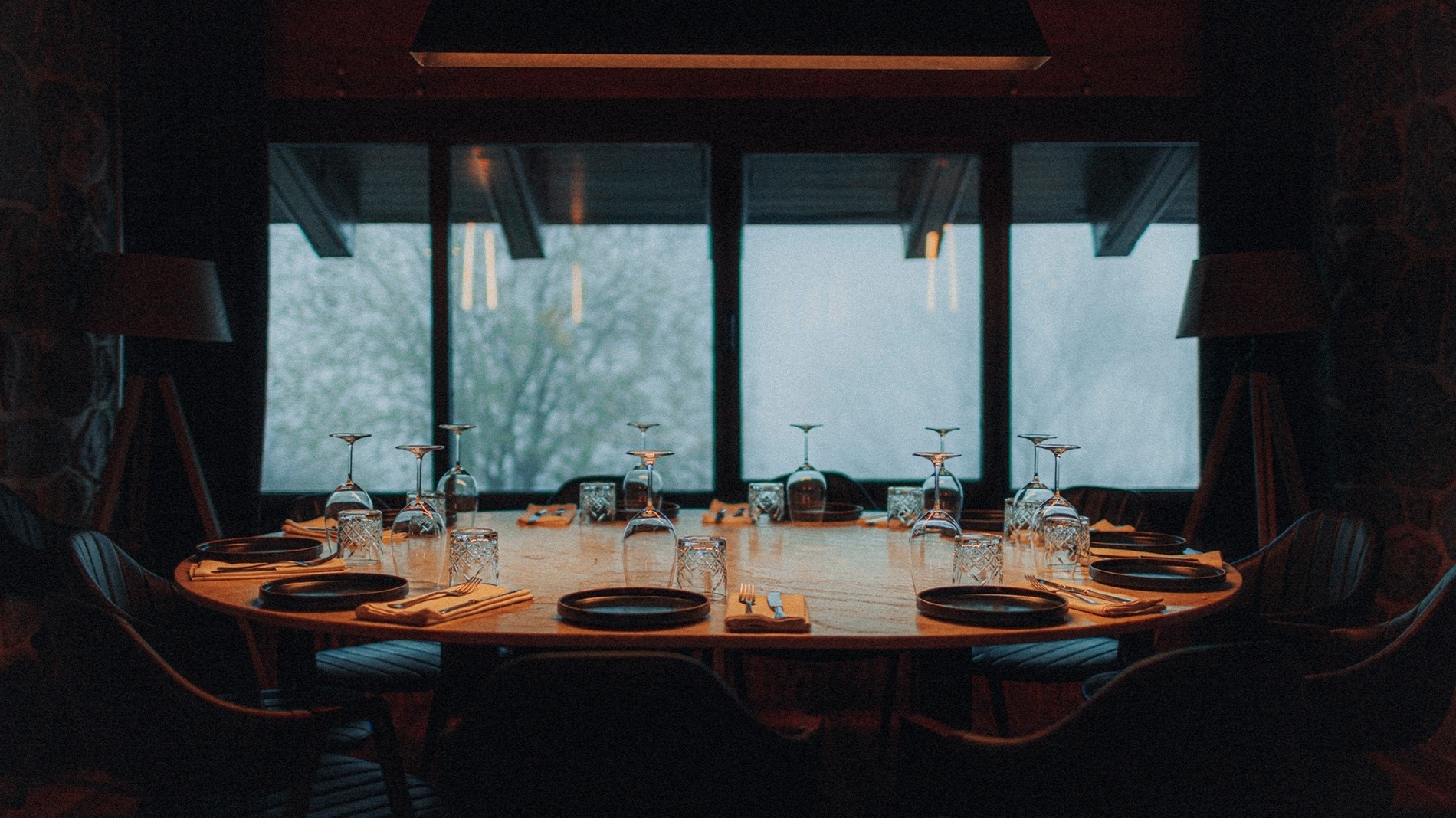 une table avec des assiettes et des verres devant une fenêtre