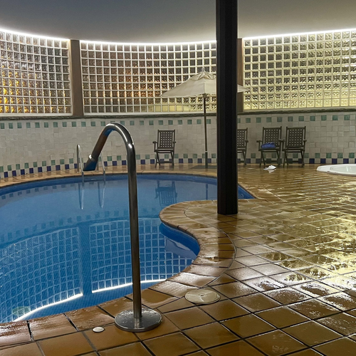Piscine intérieure SNO: Formigal, sol et murs carrelés et mouillés.