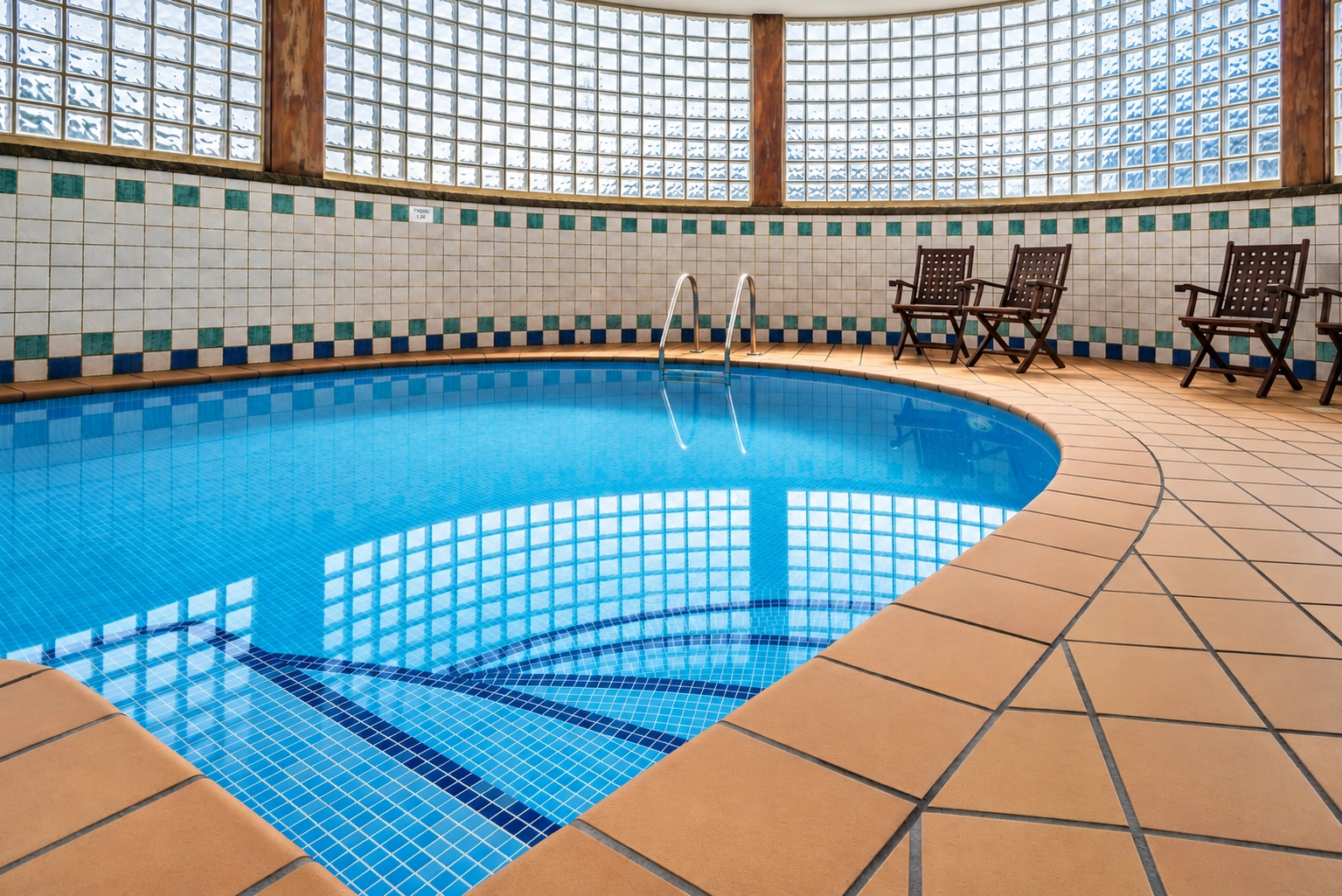 Indoor heated pool at SNO: Formigal with chairs and umbrella.