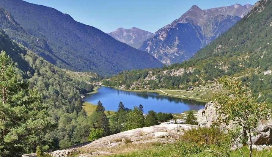 un lago en medio de un valle rodeado de montañas