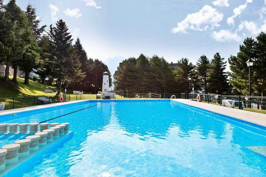una gran piscina rodeada de árboles y un faro