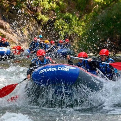 un grupo de personas remando en un río en un bote rocrol.com