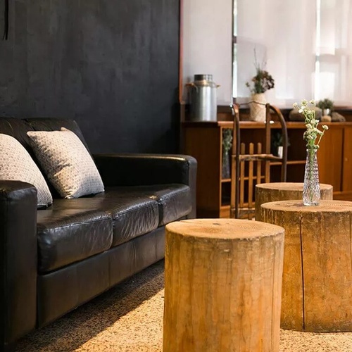 un canapé en cuir noir est assis à côté d' une table en bois